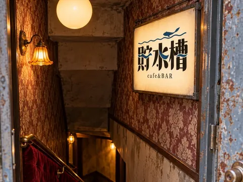 扉の奥の、地下の店へ下りる階段と看板