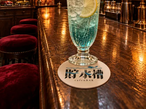 カウンターのクリームソーダと、店の名の入ったコースター